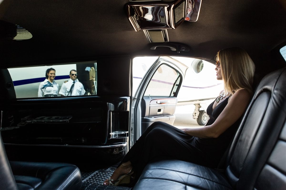 A member in a limousine arriving beside a private jet