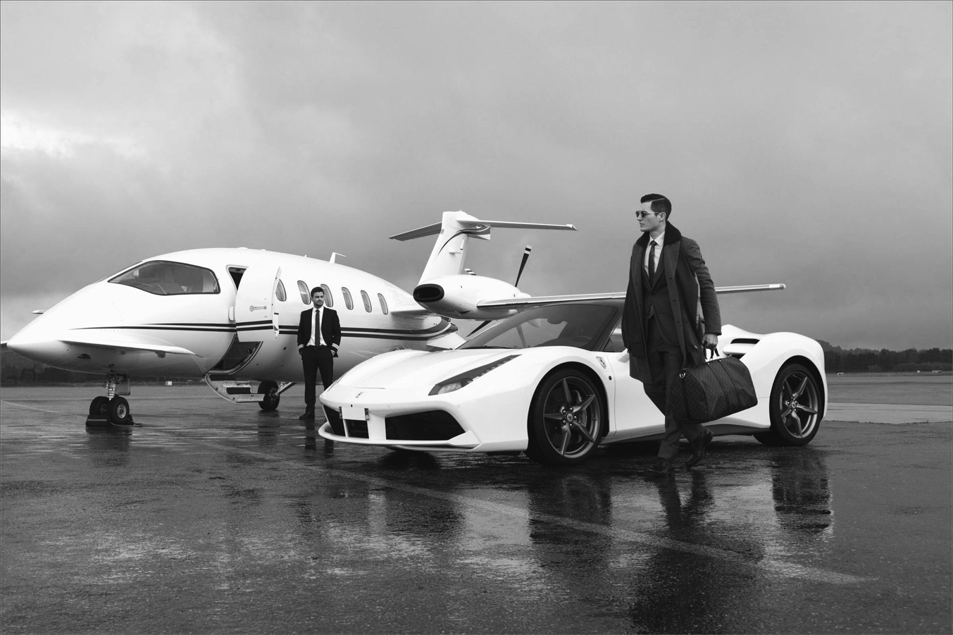 A man with a leather holdall walking between a supercar and a private jet