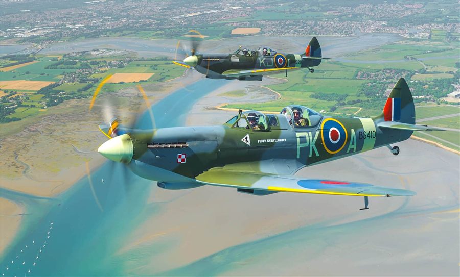 Two Spitfires flying over the English countryside